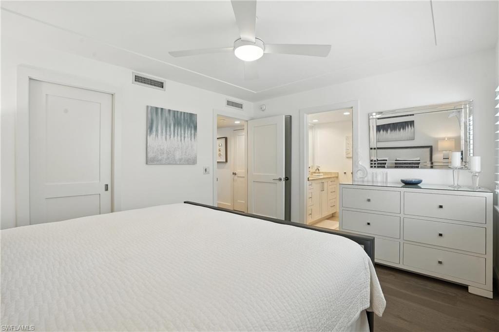 Bedroom with wood finished floors, connected bathroom, and a ceiling fan