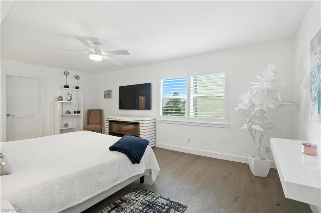 Bedroom with dark wood-type flooring and a ceiling fan