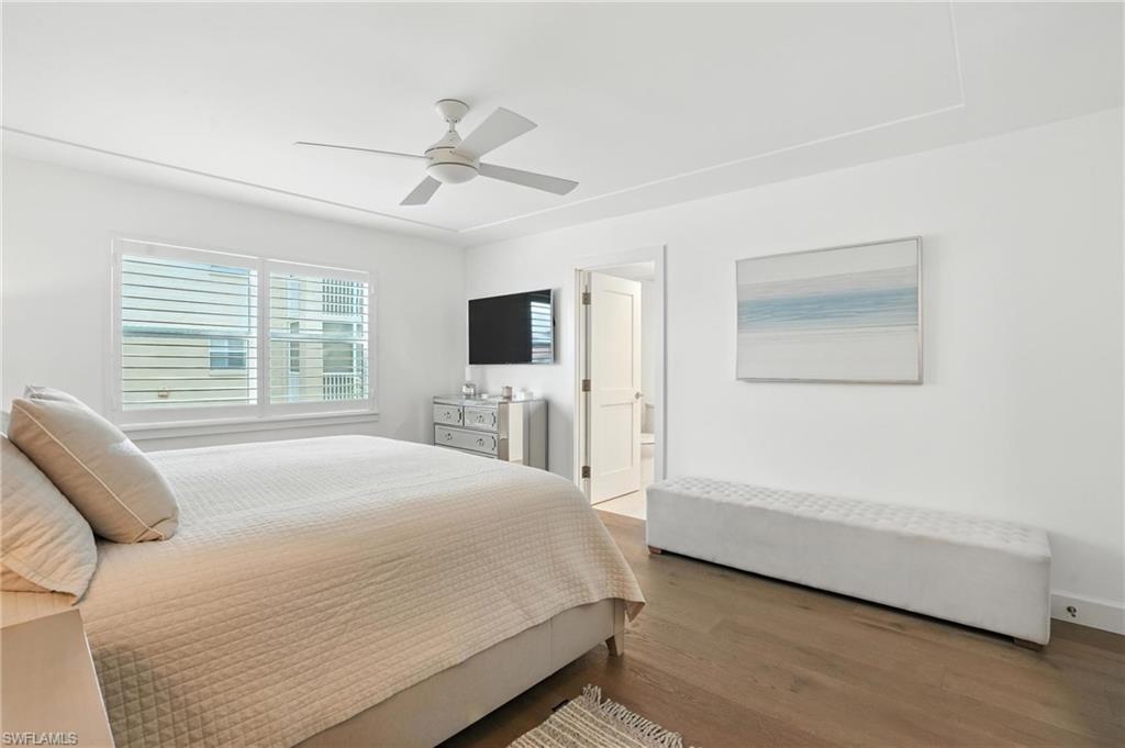 Bedroom featuring wood finished floors, ceiling fan, and connected bathroom