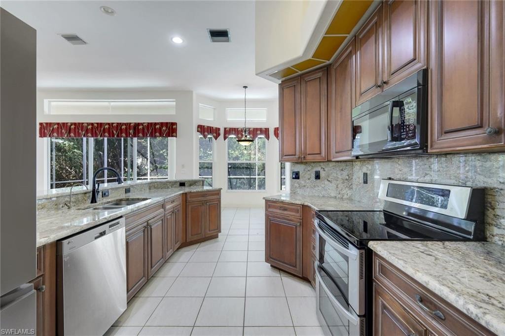 Kitchen features stainless appliances, wood cabinetry and granite countertops.