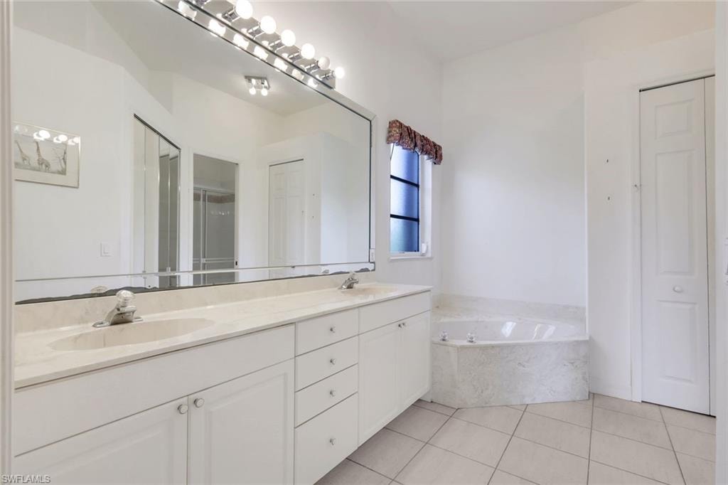 Ensuite primary bathroom features dual sinks and a soaking tub.
