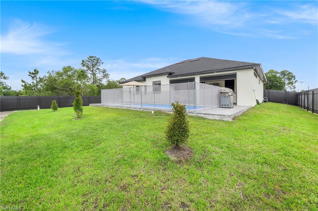 Expansive green lawn with a privacy fence