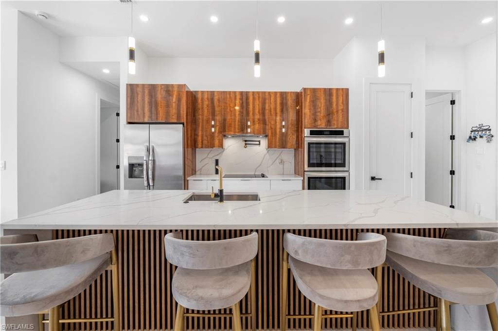 Spacious kitchen island with a waterfall countertop and a slatted wood-finish base