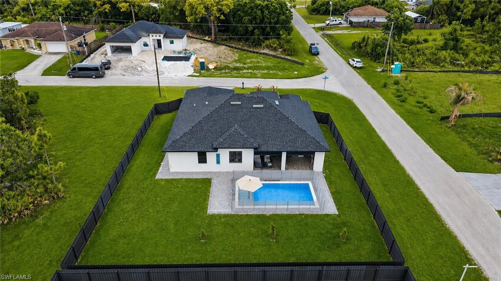 Modern single-story residence featuring a dark shingle roof and white stucco exterior