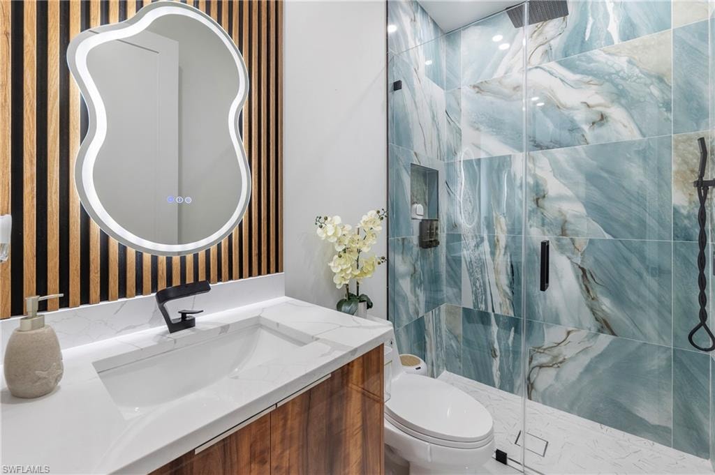 Bathroom featuring a large walk-in shower with patterned blue and white tiles, a glass enclosure, and a built-in niche