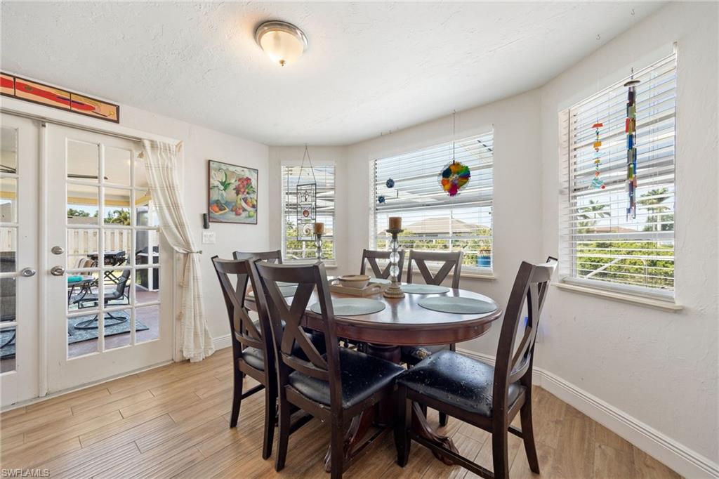 Dining area with bay windows and French doors overlooking pool and canal