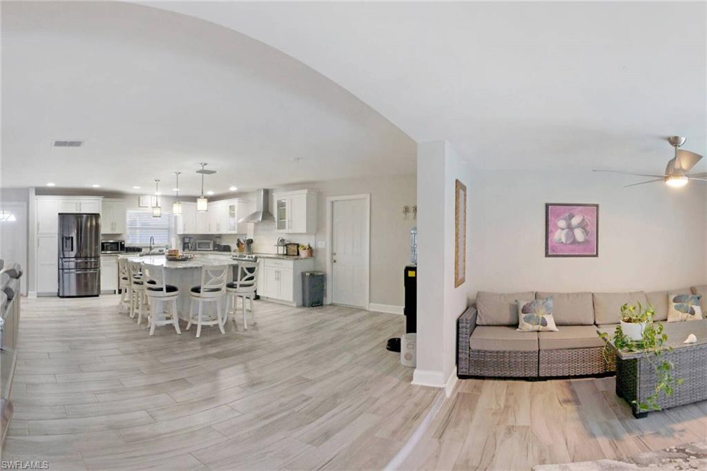 Living room with light wood finished floors and recessed lighting