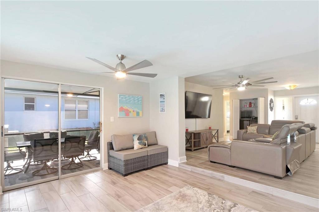 Living room with ceiling fan and wood tiled floors