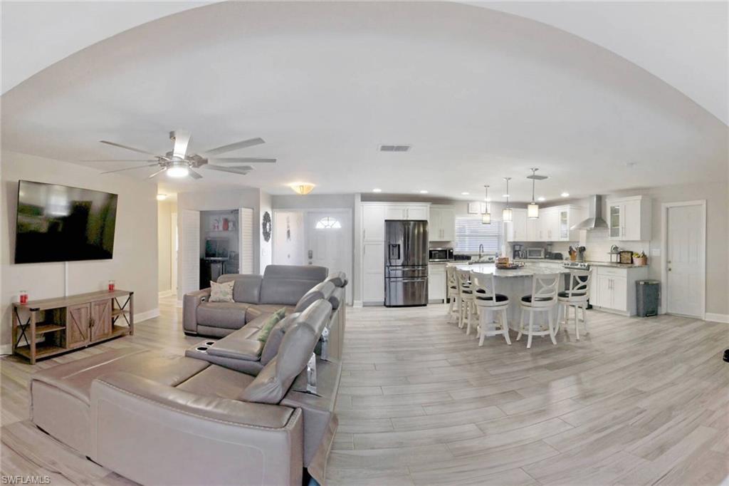 Living room featuring light wood-style floors, ceiling fan, and recessed lighting