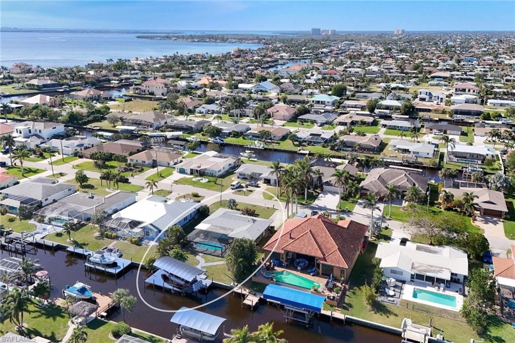 Aerial view of property and surrounding area with a large body of water and nearby suburban area