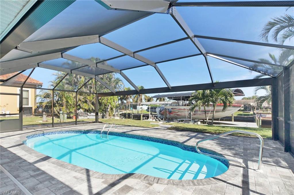 Swimming pool with a lanai, a sunroom, and a patio area