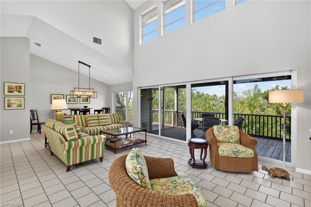 Living area with healthy amount of natural light, hanging lights, and lofted ceiling