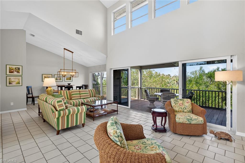 Living area featuring a high ceiling, suspended lighting, and light tile patterned floors