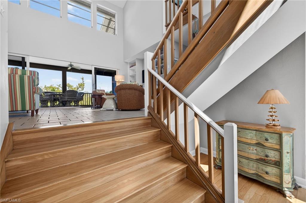 Stairway with hardwood / wood-style flooring and a high ceiling