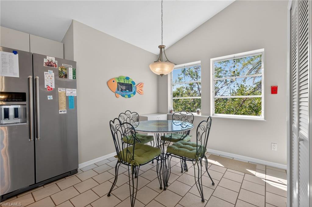 Eat-in Kitchen space with vaulted ceiling and light tile patterned floors