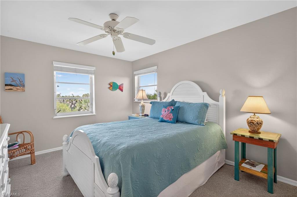 Bedroom with multiple windows, carpet, and a ceiling fan
