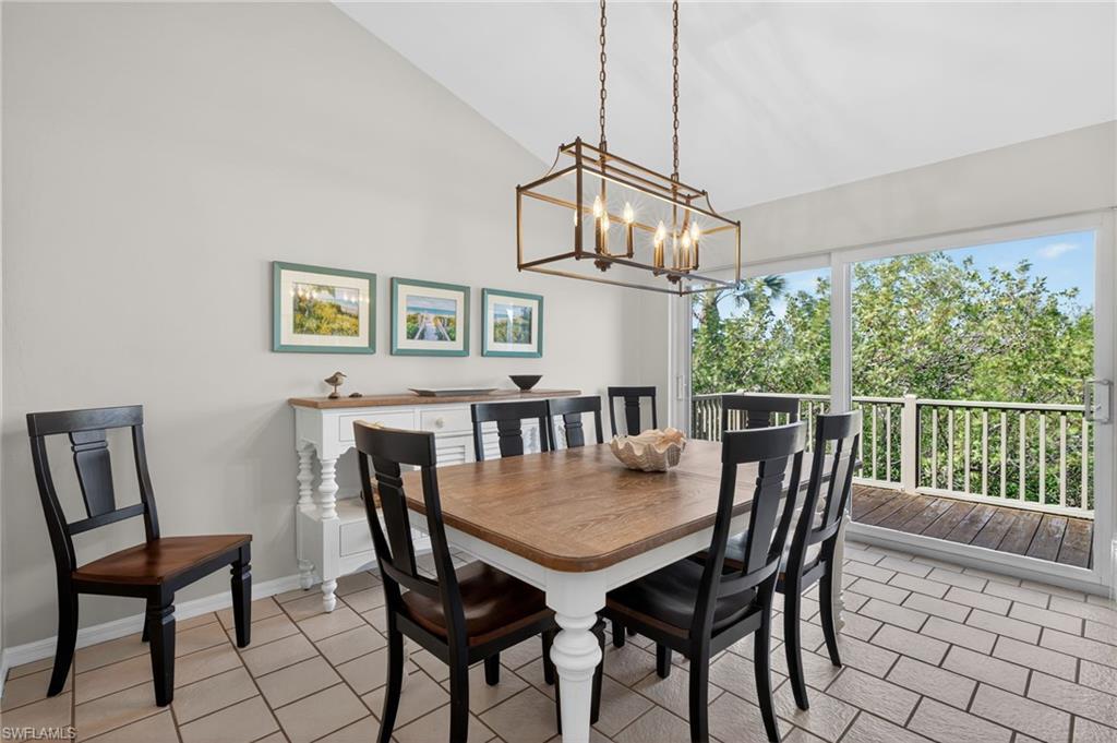 Dining space featuring vaulted ceiling, suspended lighting, and light tile patterned floors