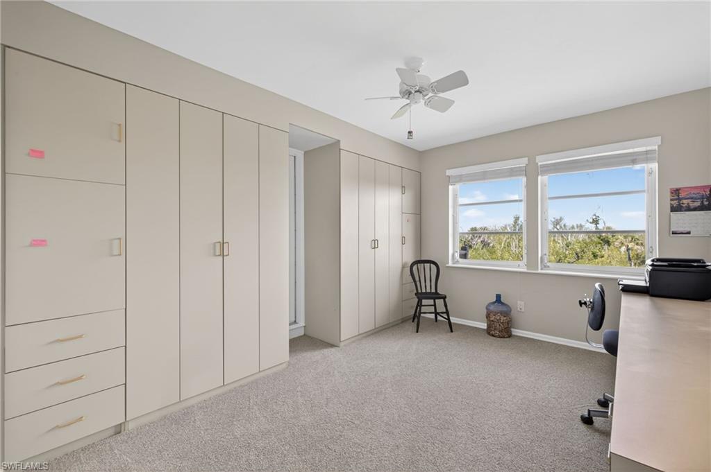Bedroom/Office space with light carpet and ceiling fan