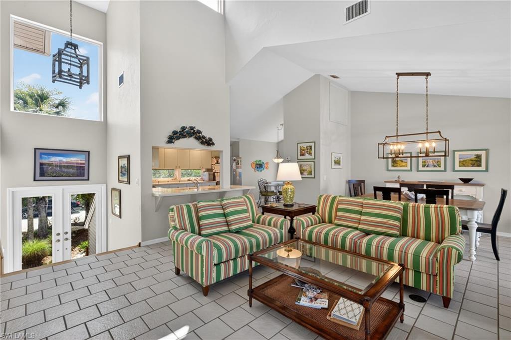 Living area featuring a chandelier, a high ceiling, and french doors