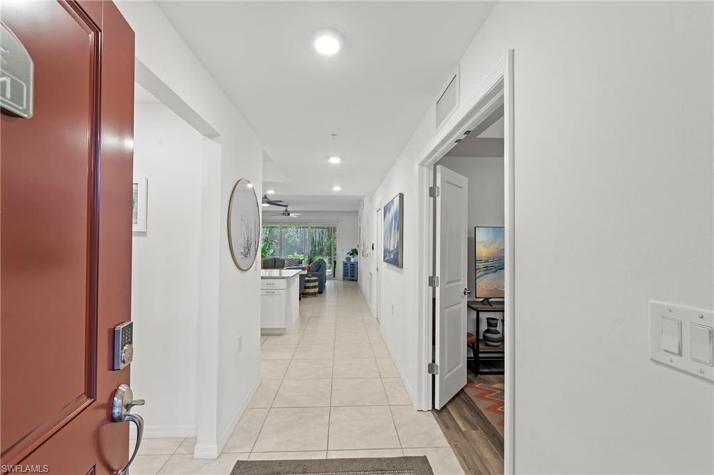 Inviting entryway with a solid door, contemporary door hardware, and light-colored tile flooring