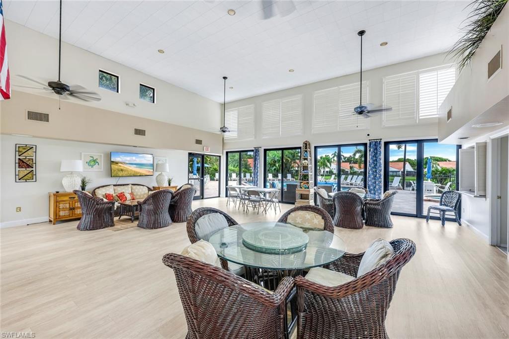 Dining area featuring light wood-type flooring, ceiling fan, and a towering ceiling