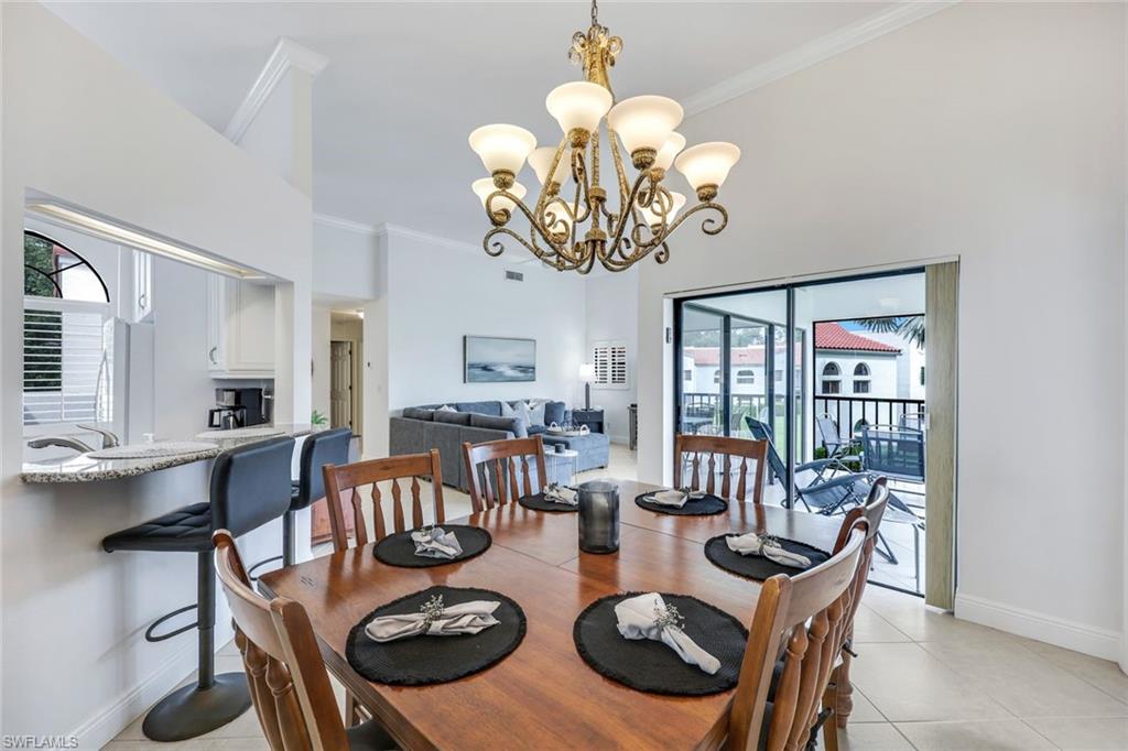 Tiled dining area featuring a chandelier and crown molding