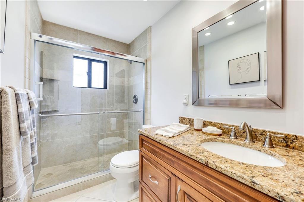 Bathroom featuring vanity, toilet, tile patterned floors, and walk in shower