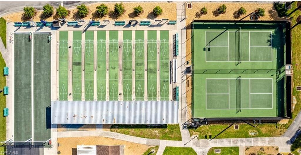 The property offers recreational amenities including two green hard-surface courts with nets, several green shuffleboard courts, and a long green lawn area