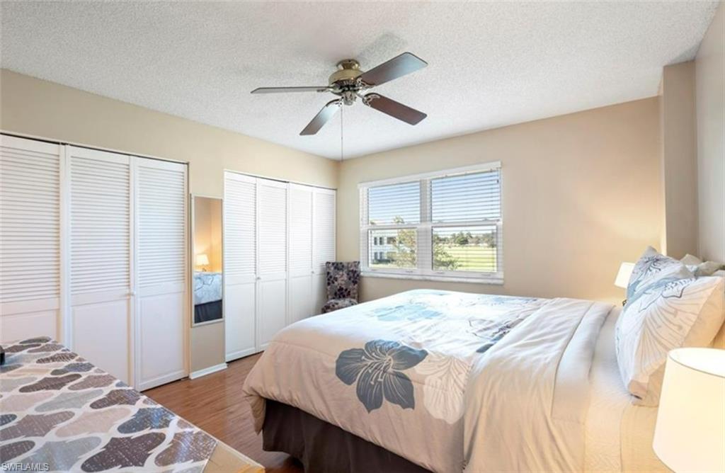 This room features wood-look flooring and ample storage with two sets of white louvered bifold closet doors