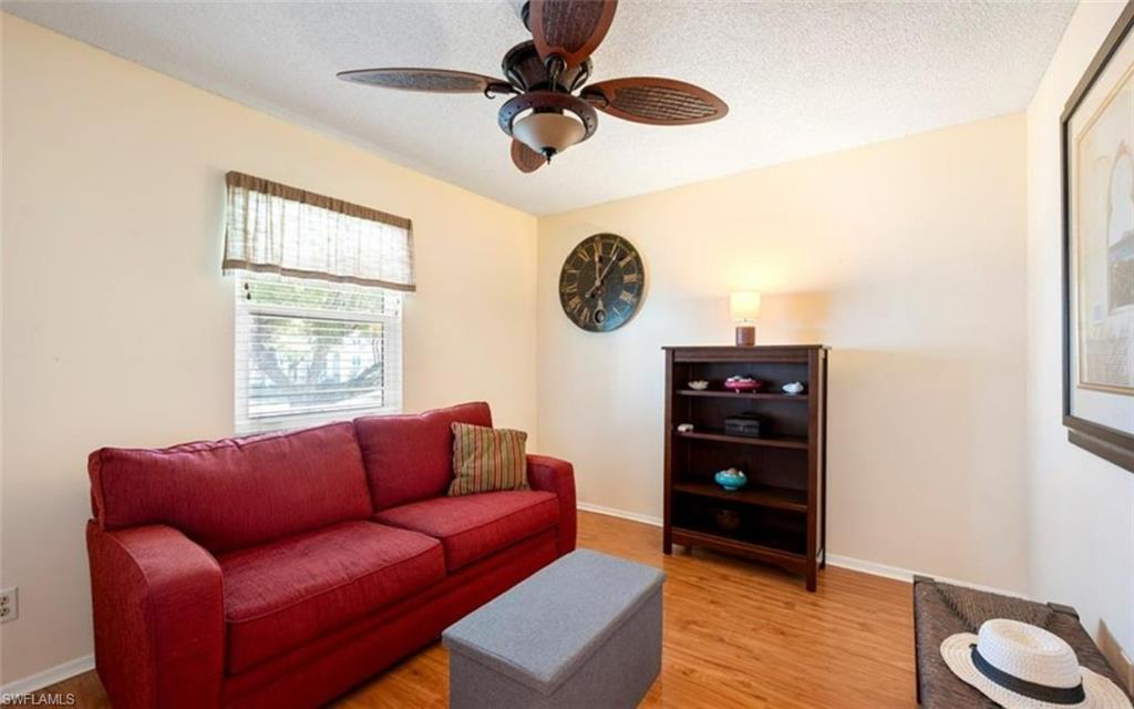 The room features a window with blinds, a ceiling fan, and light-toned walls