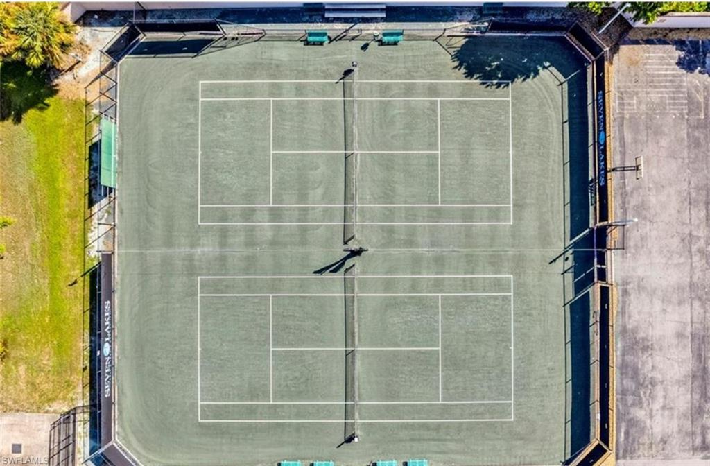 Aerial view of the two tennis courts featuring a green surface with white lines and nets