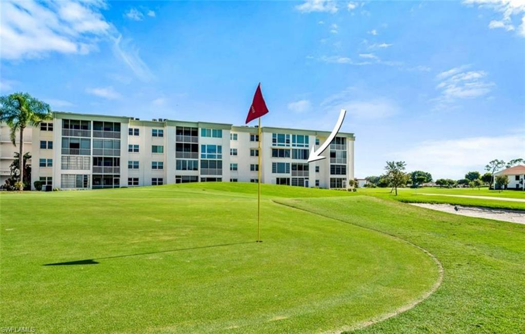 This property offers golf course views with a large expanse of green lawn and distant trees