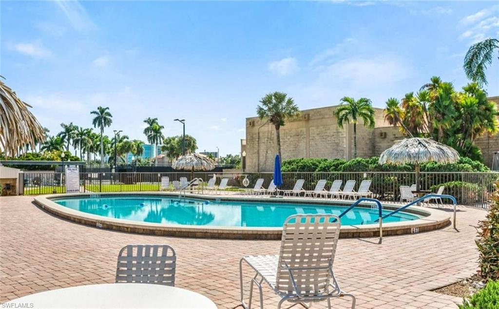 The property features an outdoor swimming pool, surrounded by a paved deck area and tropical landscaping