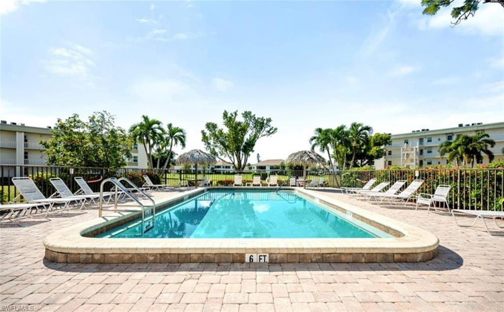 The property features an outdoor swimming pool surrounded by a paver patio and lounge chairs