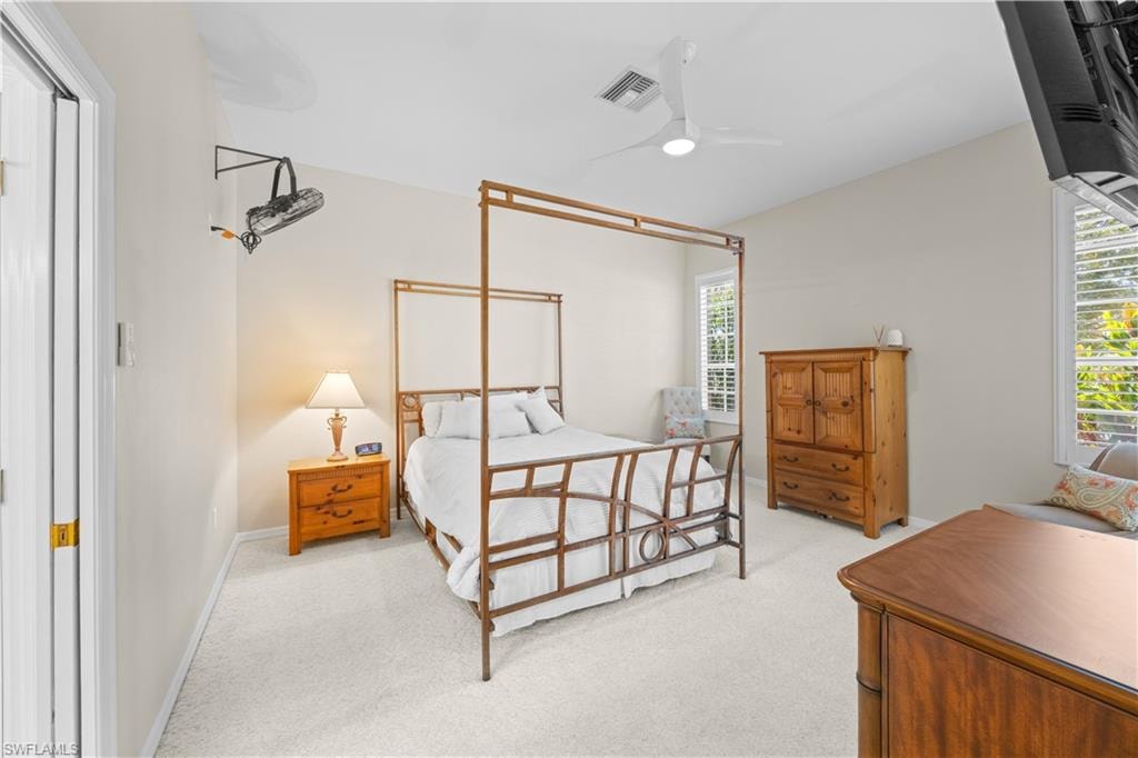 Bedroom featuring a ceiling fan, vaulted ceiling, and carpeted flooring