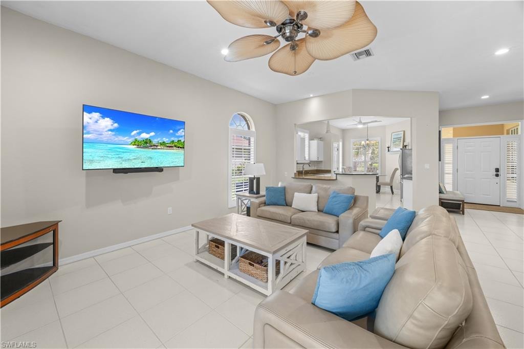 The living area features a ceiling fan, tiled flooring, and arched window
