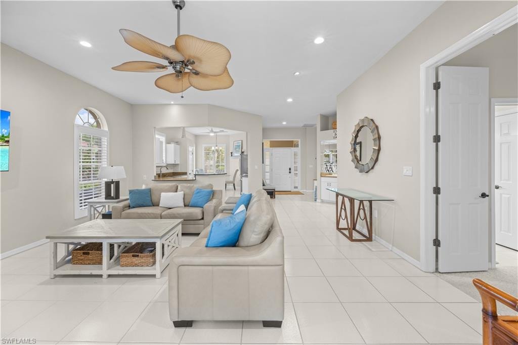 The property features an open-concept living area with light-colored tile flooring, recessed lighting, and a decorative ceiling fan