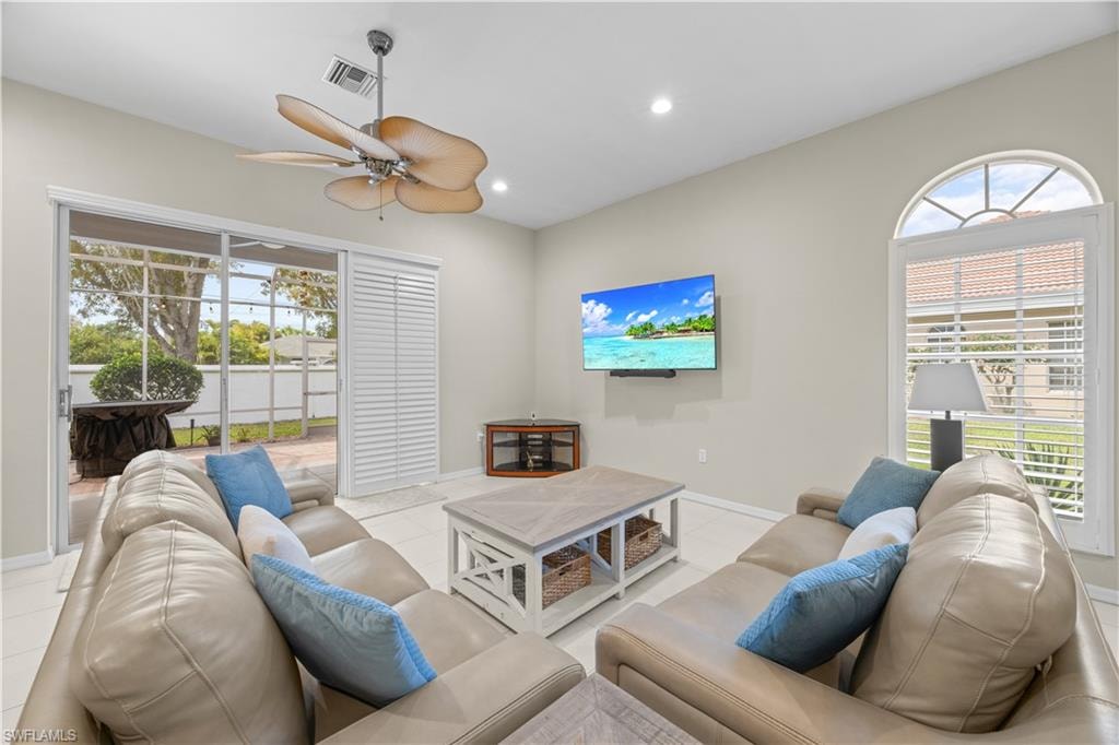 This living area features a ceiling fan, recessed lighting, and tile flooring
