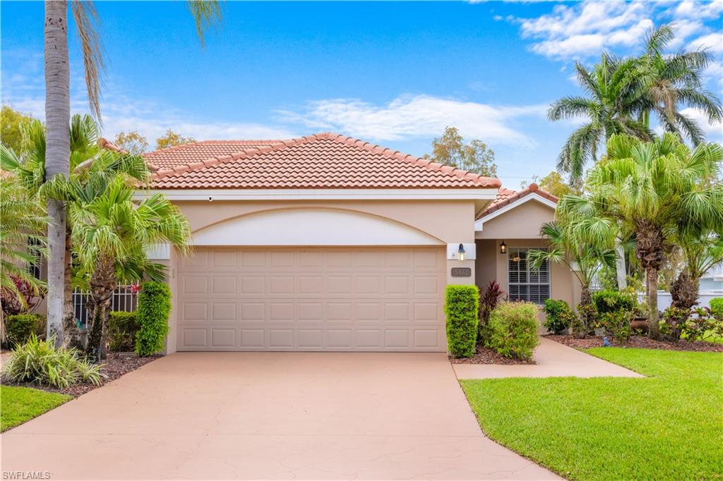 The property features a terracotta tile roof, a two-car garage, and a light-colored stucco exterior