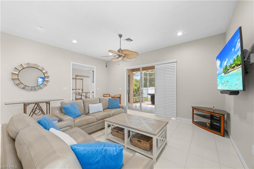 Living room featuring light-colored walls, tile flooring, and a ceiling fan