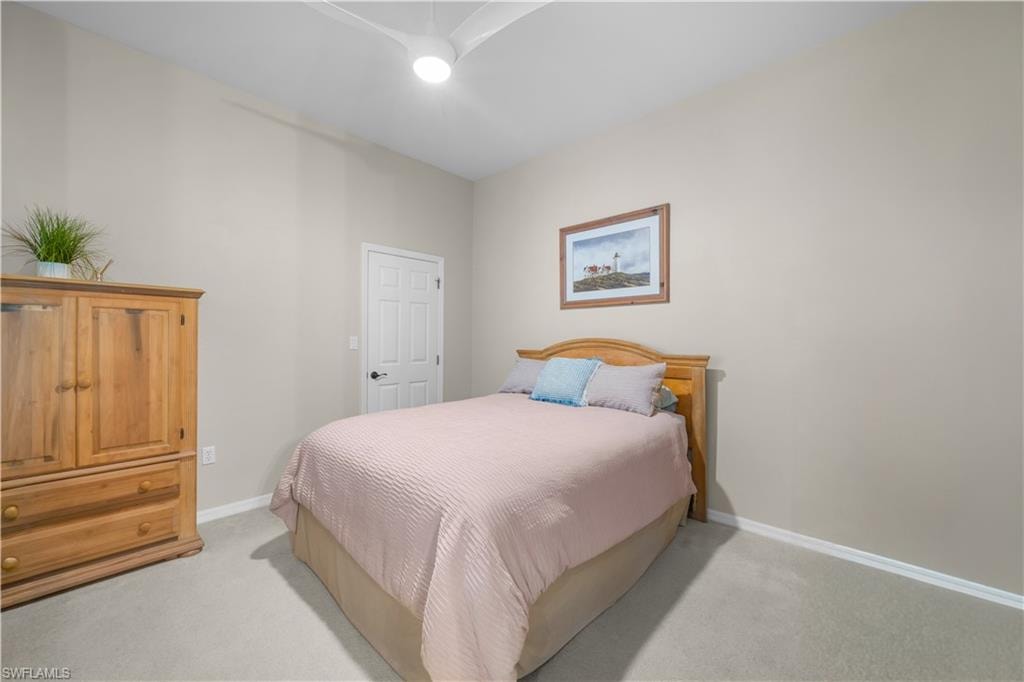 This room features neutral-toned walls, light-colored carpeting, and a ceiling fan with integrated lighting