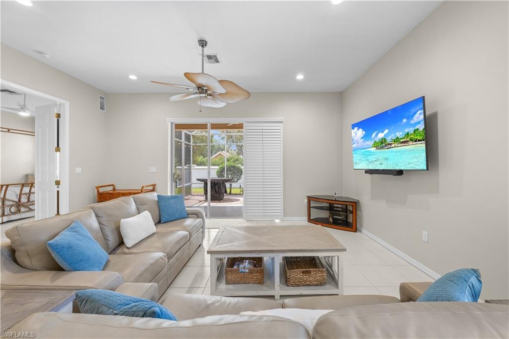 Living area featuring a ceiling fan, recessed lighting, and sliding glass doors that open to an outdoor screened patio