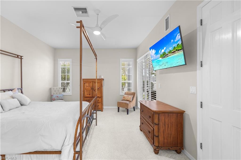 This room features light-colored walls, carpeted flooring, and a ceiling fan