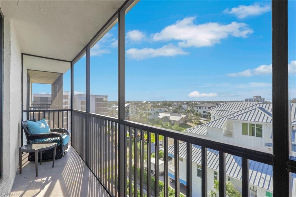 Spacious screened balcony with concrete flooring and dark metal railings
