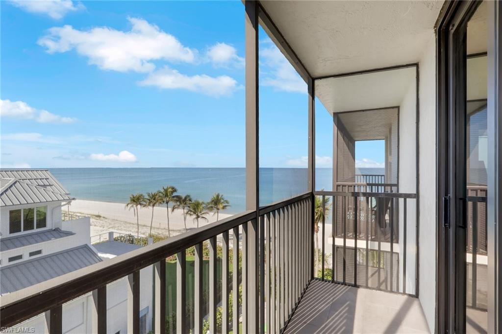 Private balcony featuring dark metal railings, concrete flooring, and a sliding glass door entry