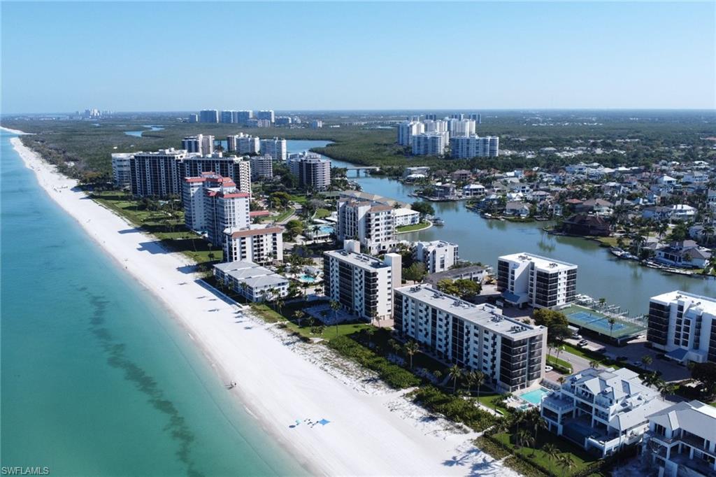 Expansive coastal property featuring a white sand beach, turquoise waters, and waterfront residences