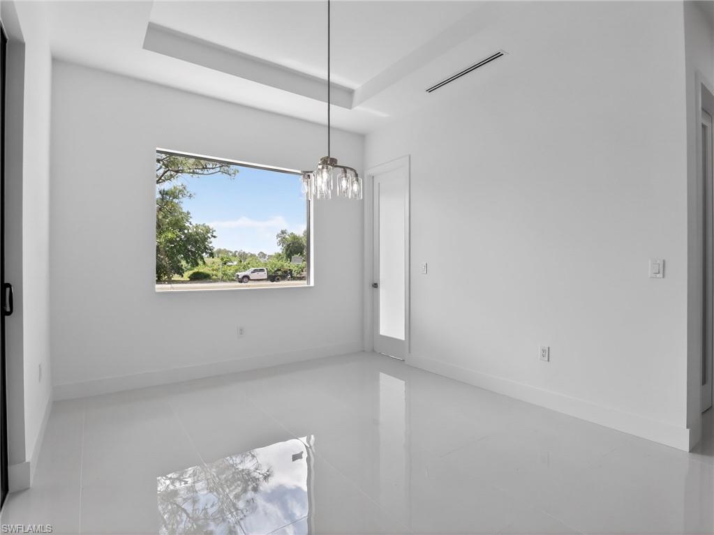 Room with white walls, a large window, and a modern light fixture
