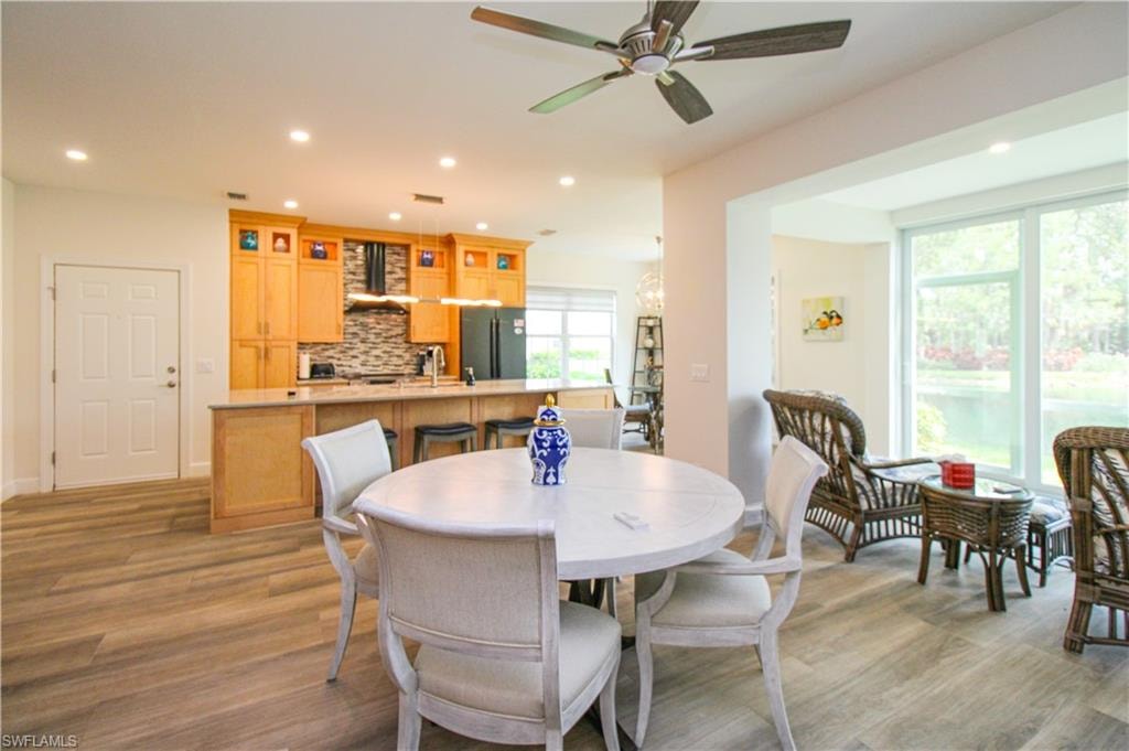 Dining room featuring sink, ceiling fan, light hardwood / wood-style floors, and a healthy amount of sunlight