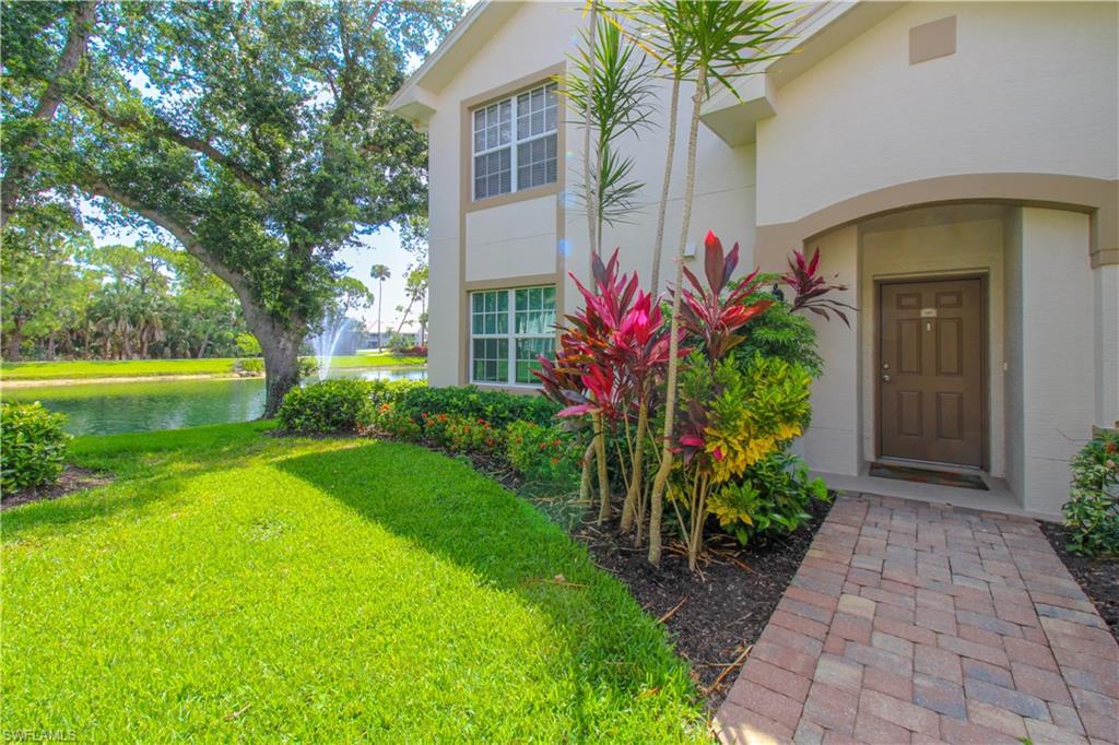 Entrance to property with a yard and a water view