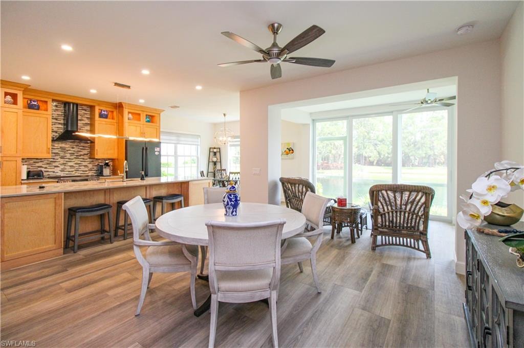 Dining space featuring ceiling fan with notable chandelier and hardwood / wood-style floors